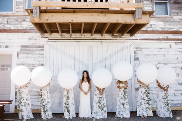 Bride and bridesmaids with balloons at rustic Washington wedding venue. Lovely Events.