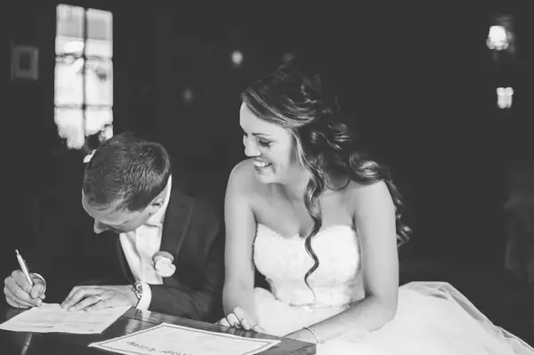 Bride and groom signing marriage certificate at Seattle-area wedding. Lovely Events.